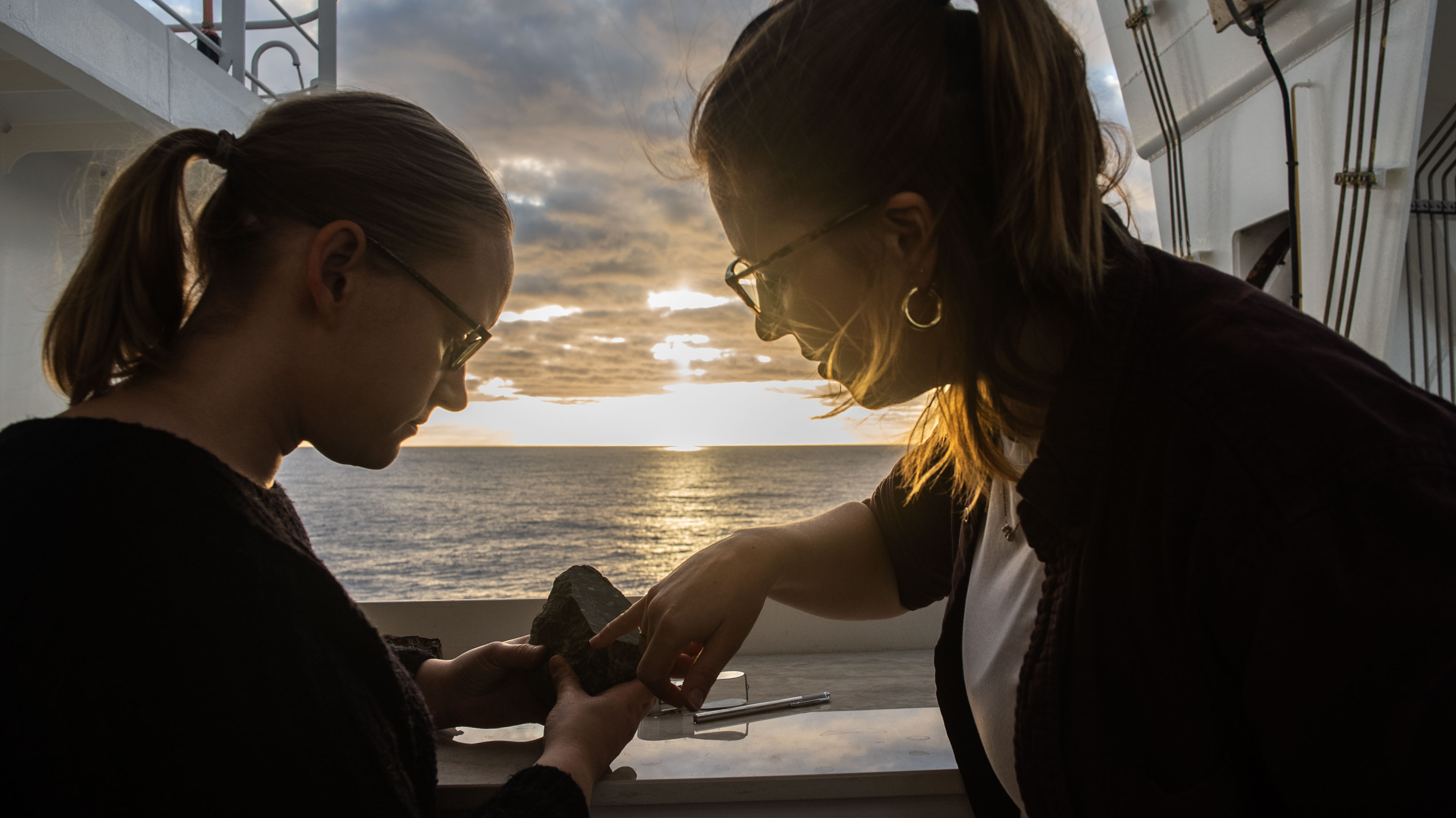 Examining seafloor rocks at sunset